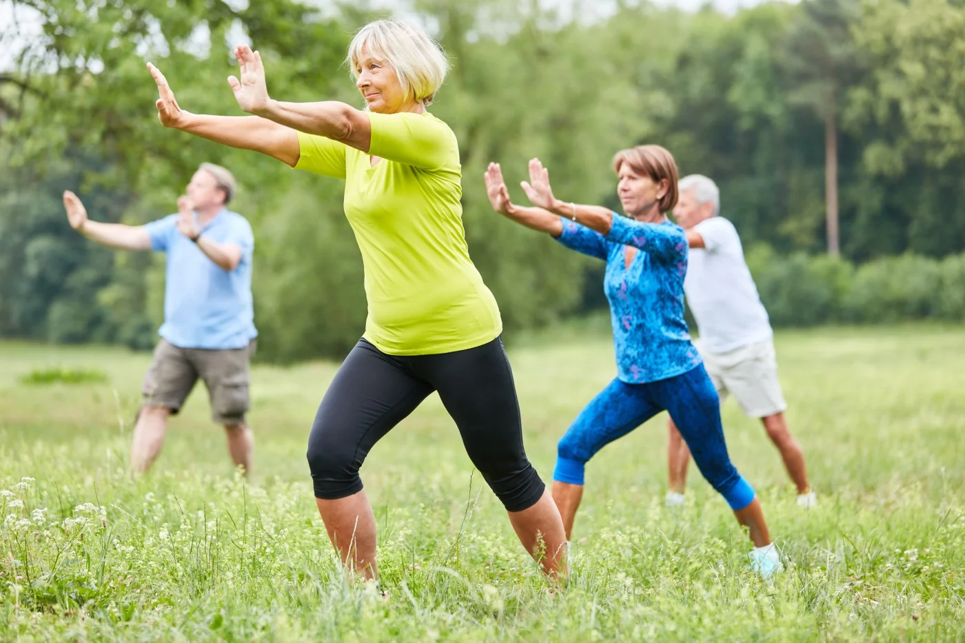 Adults practicing flowing Tai Chi movements outdoors